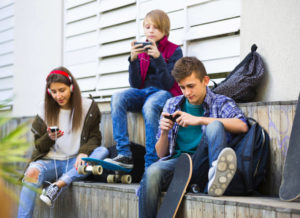 Three teenagers with smartphones by verkeorg